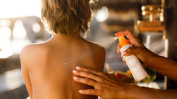 appliquer de la crème solaire sur le dos avant d'aller au soleil